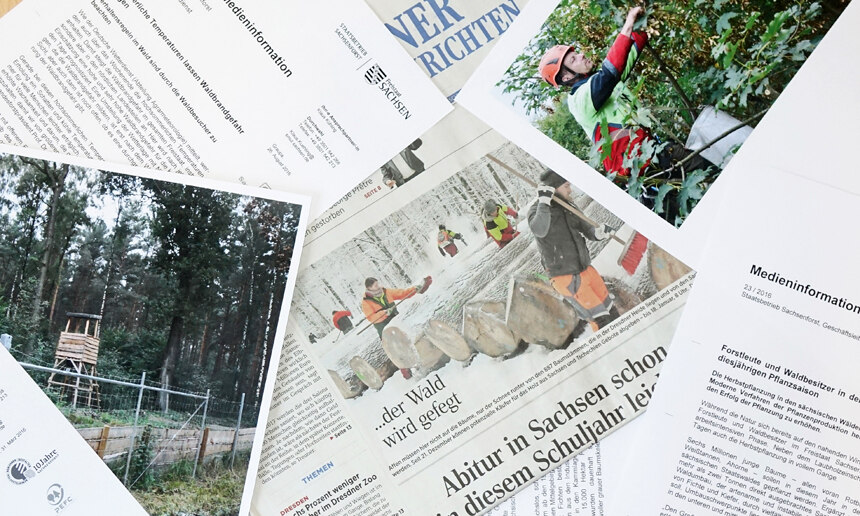 Beispielfoto mit verschiedenen Pressemitteilungen, Fotos und Zeitungsausschnitten auf einem Tisch