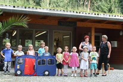 Die Kinder stehen nebeneinander vor dem Haus und singen