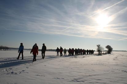 Eine Gruppe von Wanderern auf einer sonnenbeschienenen Schnee- Ebene