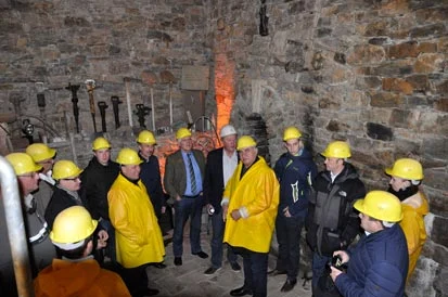 Die Besucher stehen mit Schutzhelmen in einem Gew&ouml;lbe