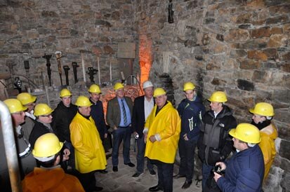 Die Besucher stehen mit Schutzhelmen in einem Gewölbe