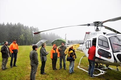 Pressevertreter neben dem Helikopter.