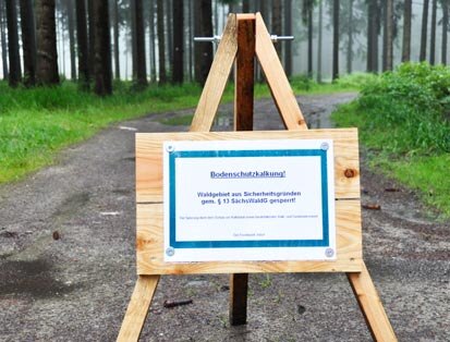 Ein Sperrschild auf einem Waldweg mit dem Hinweis zur Waldsperrung während der Kalkung.