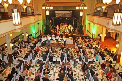 Blick in den gefüllten Saal, während Andreas Padberg den Ball auf der Bühne eröffnet.