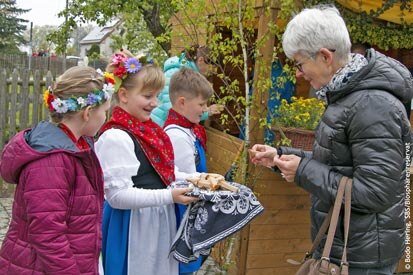 Kinder in sorbischer Tracht begrüßen Besucher mit Brot und Salz