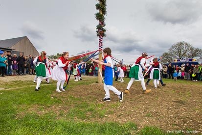 Schüler in bunten Trachten beim Tanz am Maibaum