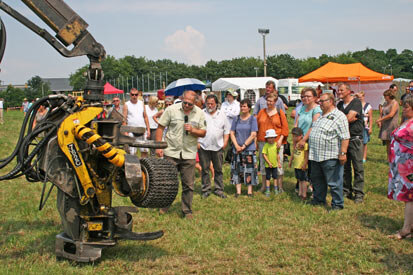 Ein Mitarbeiter mit Mikrofon erklärt den Besuchern die Funktionsweise enes Harvesters.