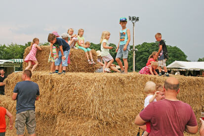 Kinder spielen auf Strohballen.