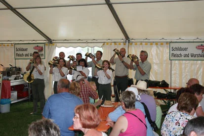 Die Jagdhornbl&auml;sergruppe spielt im Zelt vor Besuchern.