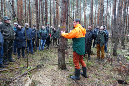 Herr Martens spricht im Wald zu den Tagungsteilnehmern