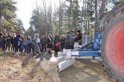 Besucher der Auftaktveranstaltung besichtigen eine Maschine zum Wegebau