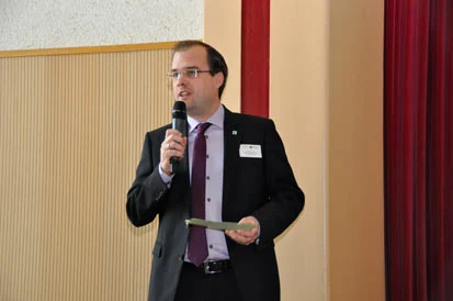 Klaus K&uuml;hling mit Mikrofon in der Hand spricht zu den G&auml;sten