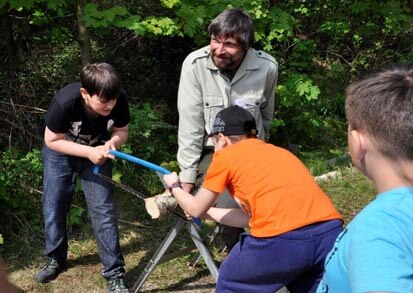 Zwei Kinder zersägen ein Holzstück