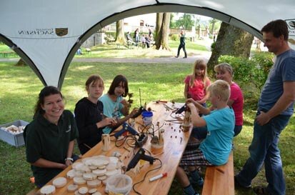 Kinder sitzen an einem Tisch und basteln.