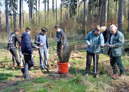 Links Sch&uuml;ler beim Pflanzen, in der Mitte ein K&uuml;bel mit Pflanzen und rechts Prof. Dr. Braun im Gespr&auml;ch mit Projektleiterin Frau Kerstin Richter 