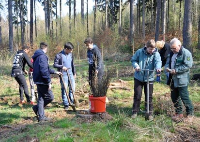 Links Schüler beim Pflanzen, in der Mitte ein Kübel mit Pflanzen und rechts Prof. Dr. Braun im Gespräch mit Projektleiterin Frau Kerstin Richter 