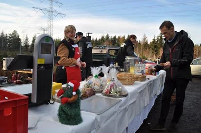 Eine Verk&auml;uferin am Imbissstand verkauft einem Gast eine Bratwurst.