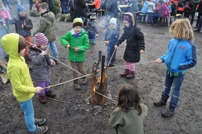 Kinder halten St&ouml;cke an eine schwedische Fackel.