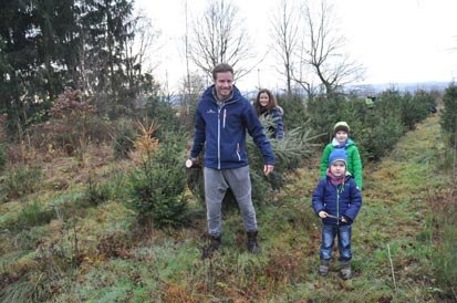 Eine vierköpfige Familie auf der Weihnachtsbaumplantage.