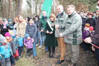 Minister Schmidt und Forstbezirksleiter Padber durchtrennen gemeinsam mit der Waldk&ouml;nigin ein Absperrband.