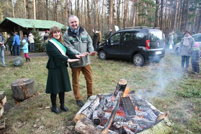 Staatsminister Thomas Schmidt  und die Waldk&ouml;nigin w&auml;rmen ihre H&auml;nde am Lagerfeuer.