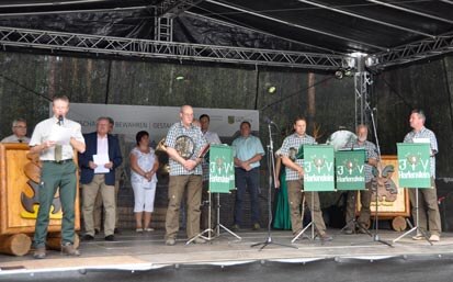 Bert Schmieder auf der Bühne mit einer Jagdhornbläsergruppe